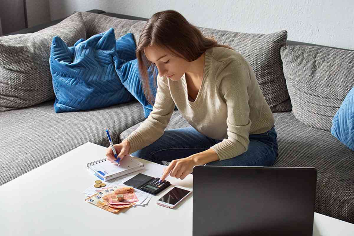 © Lukasz - stock.adobe.com Frau mit Taschenrechner und Bargeld