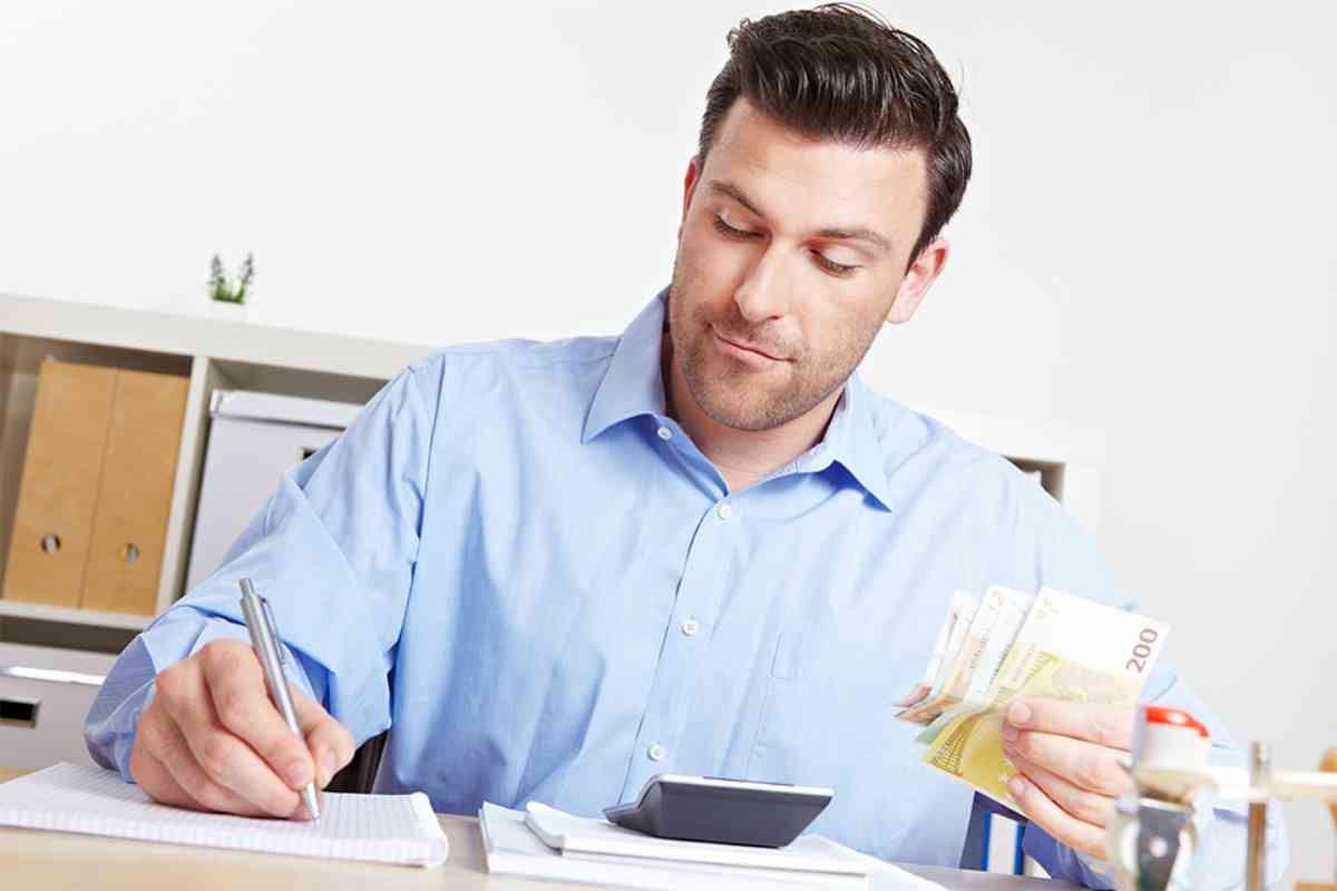 Mann mit Stift und Geldscheinen in den Händen